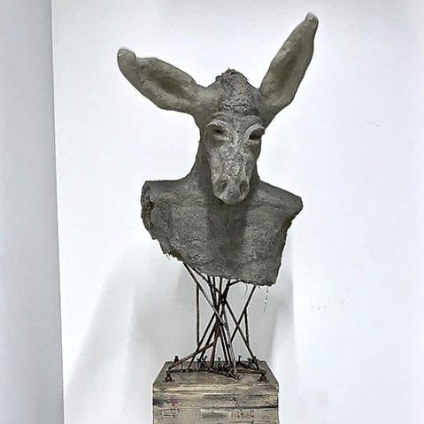Ce buste, Le Therianthrope de Passion & Créations, est maintenu par des tiges en métal sur un socle.