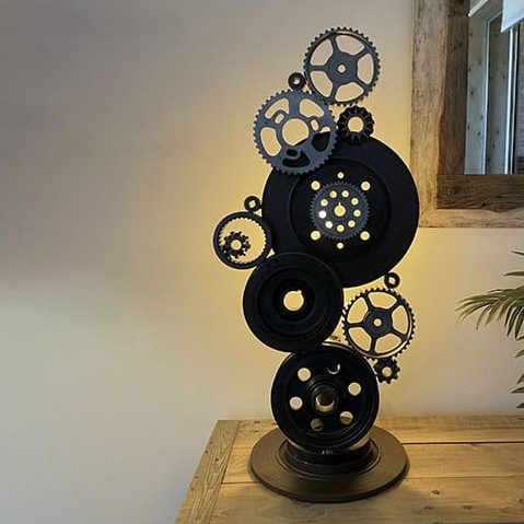 Cette création est un mélange entre une sculpture et une lampe composée d'engrenages recyclés.