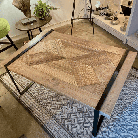 Table basse de salon rectangulaire, le plateau est une mosaïque de vieux bois brossé et les pieds sont en métal noir.