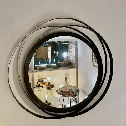 miroir rond avec plusieurs cercles qui se croisent en métal noir.